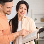 Religious,Couple,Reading,Holy,Bible,In,Kitchen