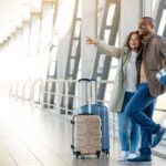 Joyful,African,American,Couple,Standing,With,Luggage,At,Airport,And