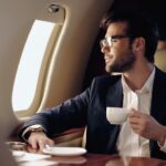 Smiling,Businessman,Holding,Cup,And,Looking,At,Window,In,Private