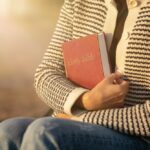 A,Woman,Embracing,The,Holy,Bible,To,Her,Chest,In