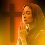 Woman,Praying,In,Front,Of,Christian,Cross,,Surrounded,By,Warm